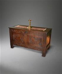 A Charles II oak coffer with bird carving.