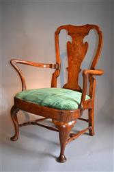 An early 18th century elm low elbow chair.