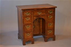 An elegant George II walnut kneehole desk.